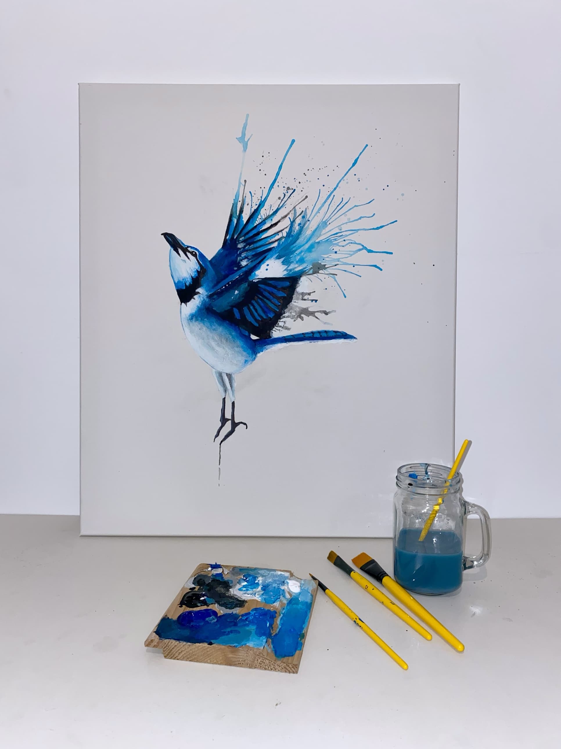 A finished canvas in the studio, with the palette and brushes used to paint it